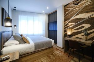 a bedroom with a bed and a desk at IL FOCOLARE Premium Suites in Avilés