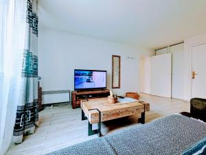 a living room with a tv and a wooden table at Chic apart with bar in Paris in Saint-Denis