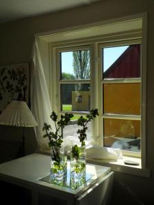 un jarrón con flores en una mesa junto a una ventana en B&B Rosenørn - Nyborg, en Skalkendrup