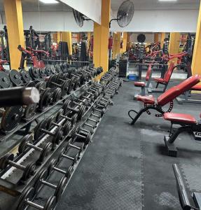 a gym with many rows of dumbbells in a room at Hotel NEU 354 in Neuquén