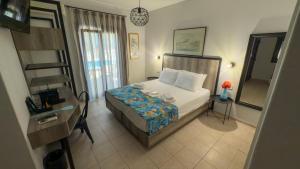 a bedroom with a bed and a desk and a mirror at Aliston Hotel Thassos in Skala Potamias