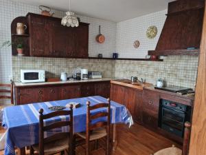 a kitchen with a table and a microwave at Le Nid du Bocage in Sevremont