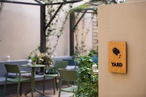 a room with chairs and tables and a sign that says yard at Living Yard Acropolis in Athens