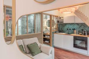 a kitchen and living room with a couch and a mirror at Le Grand Bastion, Luxury T2 - avec climatisation in Lescar +5 photos