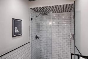 bagno con doccia e piastrelle bianche di 1st floor King Suite Downtown Boutique Hotel a Savannah