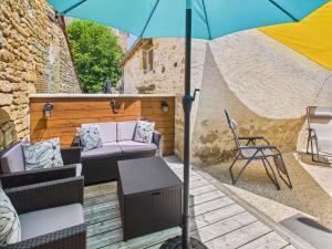 a patio with a chair and an umbrella at Escapade à 2 sur Auriac avec jardin cosy in Auriac-du-Périgord