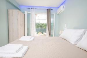 a bedroom with a bed with two towels on it at Corfu Blue Memories Apartment 2 in Corfu Town