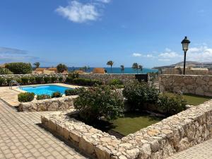 a stone retaining wall next to a swimming pool at Exclusive Villa Romeo mit privaten Pool, mit herlichen Panoramameerblik auf den Atlant in Costa Calma