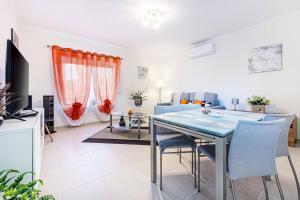Un comedor y una sala de estar con mesa y sillas. en Atlantic Breeze Apartment, en Armação de Pêra