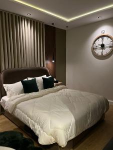 a bedroom with a large bed with a clock on the wall at Quiet studio with comfortable hotel bed in Riyadh