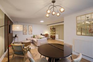 a living room with a table and chairs at Monarch House - Serviced Apartments - Kensington in London