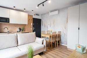 a living room and kitchen with a couch and a table at HostLoop Apartments - Świętego Pawła 10 in Katowice