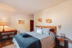 a bedroom with a bed and a table with a lamp at Villa Luciana - Radiante casa vecina del mar in Son Bou