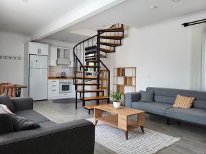 a living room with two couches and a spiral staircase at Villa Da London in Dalaman