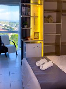 ein Bett mit zwei Handtüchern auf einem Zimmer in der Unterkunft Hotel do Reinildo II in Cachoeira Paulista