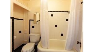 a bathroom with a white toilet and a shower at Mary Lambert - Historic Hotel in Cimarron