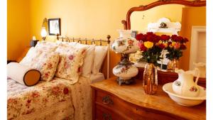 a bedroom with a bed and a table with a mirror at Mary Lambert - Historic Hotel in Cimarron