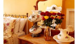 a table with two vases and flowers on it at Mary Lambert - Historic Hotel in Cimarron