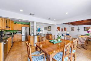 a kitchen and dining room with a wooden table and chairs at Casa Balsinde - Delight in a Private Pool in the Southern End of West Palm in West Palm Beach +17 photos
