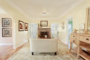 a living room with a fireplace and a white couch at Casa Paradiso - A Sun Drenched Escape with Poolside Cabana Charm in West Palm Beach