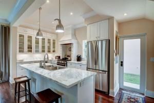 a large kitchen with white cabinets and a large island at Grey Mist - Recharge in a Stylish Home Near Downtown in West Palm Beach