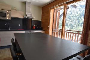 ヴォジャニーにあるVAUJANYLOCATIONS - Silenes04のキッチン(テーブル、椅子付)、大きな窓が備わります。 +8枚の写真