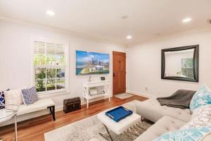 een woonkamer met een bank en een tafel bij Key Lime Cottage - Bask Poolside in a Historic Flamingo Park Gem in West Palm Beach