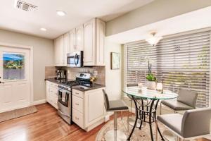 een keuken met een tafel en een fornuis bovenste oven bij Key Lime Cottage - Bask Poolside in a Historic Flamingo Park Gem in West Palm Beach