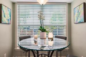 een eettafel met een vaas met bloemen erop bij Key Lime Cottage - Bask Poolside in a Historic Flamingo Park Gem in West Palm Beach +14 foto's