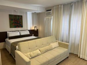 a living room with a couch and a bed at Hotel Borges Lagoa Pq Ibirapuera 1116 in São Paulo