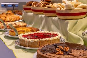 a table filled with pies and pastries on plates at Hotel NEU 354 in Neuquén +62 photos