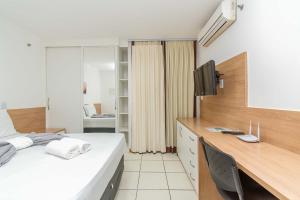 Un dormitorio con una cama y un escritorio con televisión. en Life Resort Hotel em Brasília 49259, en Brasilia