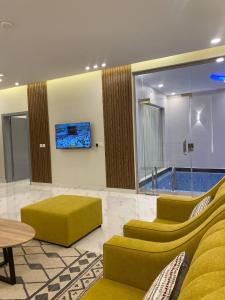 a living room with a yellow couch and a table at بلو هيفن in As Sayl aş Şaghīr