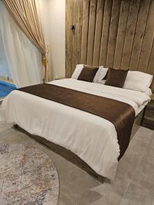 a bedroom with a large bed with a wooden wall at بلو هيفن in As Sayl aş Şaghīr +32 photos