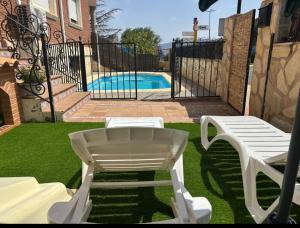 two white chairs and a table and a pool at CASA DE ONIL in Onil