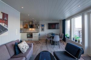a living room with a couch and a table at Luxurious cabin by the waterfront in Leknes