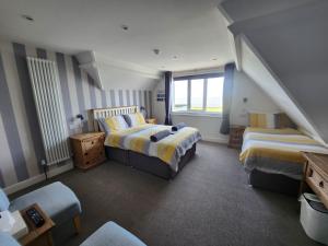 a bedroom with two beds and a window at South Beach B & B in Lowestoft