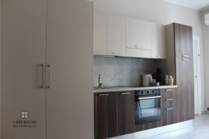 a kitchen with white cabinets and a stove top oven at Sapri Rooms in Lamezia Terme