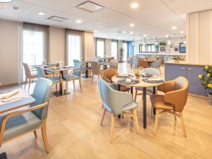 une salle à manger avec des tables et des chaises dans l'établissement Zenitude Hôtel-Résidences Chambéry, à Chambéry