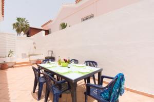 einen Tisch und Stühle auf der Terrasse eines Hauses in der Unterkunft Tranquil 4 Bedroom Holiday Villa in Callao Salvaje
