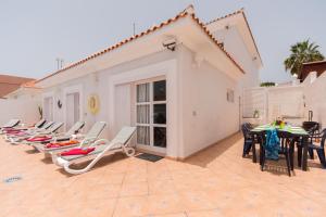 eine Reihe von Liegestühlen und Tischen auf einer Terrasse in der Unterkunft Tranquil 4 Bedroom Holiday Villa in Callao Salvaje