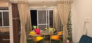 a living room with a table and chairs and a window at Soni & Avi Home in Igatpuri