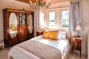 a bedroom with a large bed and a chandelier at Casal Santa Virginia in Sintra +37 photos