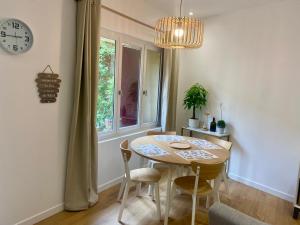a dining room with a table and chairs and a clock at Le patio Provençal-Maison avec cour privée in Nîmes