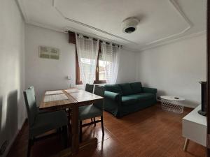 a living room with a table and a green couch at Ortuella Apartment in Ortuella