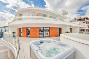 un jacuzzi en el balcón de una casa en Baltic Park Molo, Sun & Snow, en Świnoujście