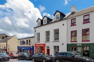 a street with cars parked in front of buildings at Dingle Heritage Townhouse in Dingle