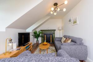 a living room with two couches and a table at Dingle Heritage Townhouse in Dingle
