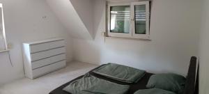 a bedroom with a bed and a dresser and a window at Cosy Apartment Geislingen in Geislingen an der Steige +5 photos