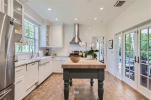 a kitchen with white cabinets and a center island at Palm Beach Oasis - Indulge in Garden Tranquility with Alfresco Dining in West Palm Beach +10 photos